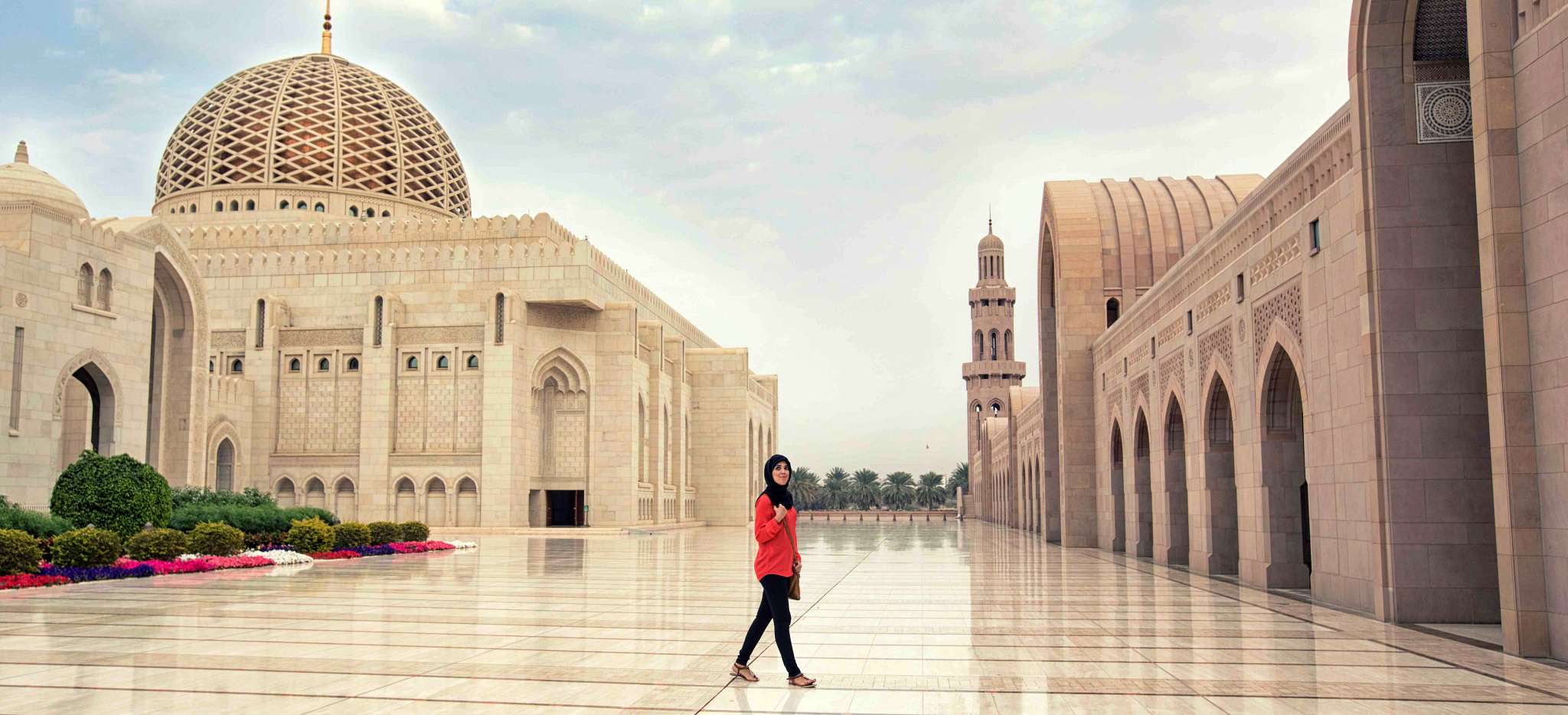 Frau wandert beeindruckt durch die große Moschee von Muskat
