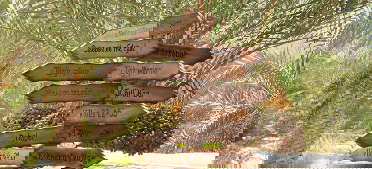 Hölzerne Schilder im Dattelwald des "Six Senses Zighy Bay" im Oman