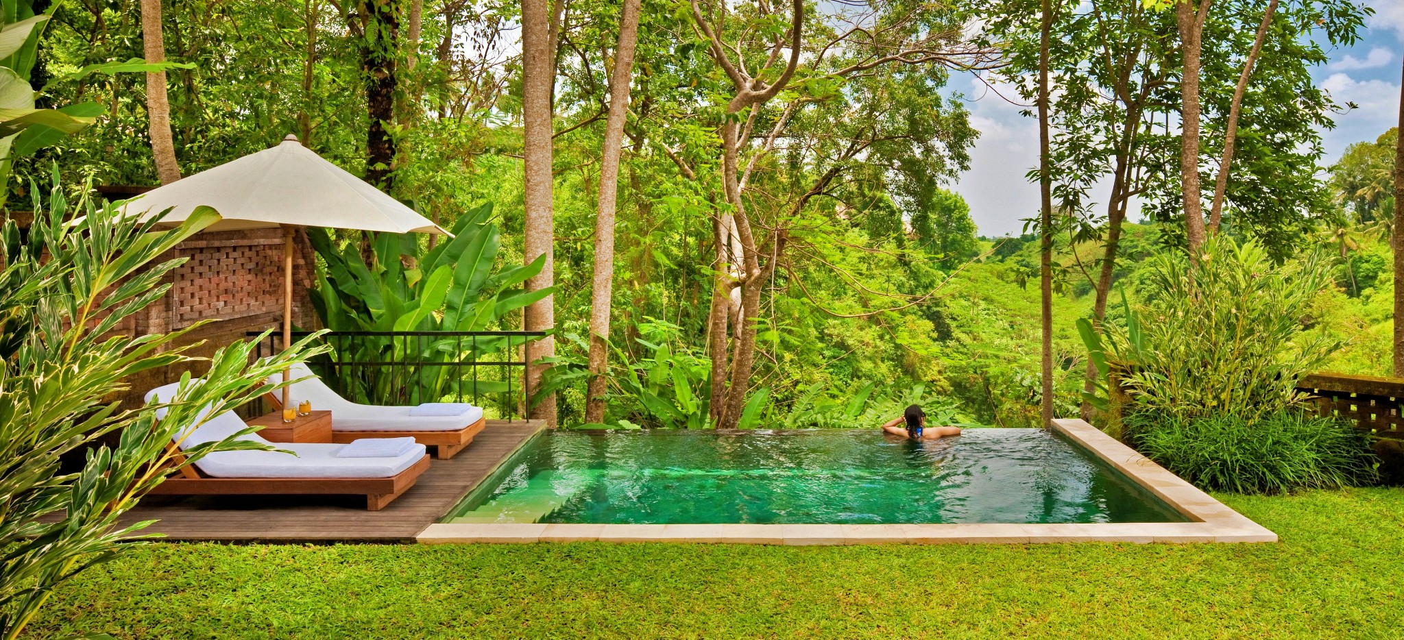 Ein Pool zwischen einem englischen Rasen und dem balinesischen Dschungel