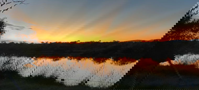 Ein Sonnenuntergang am Fluss im Mokaikai Private Reserve